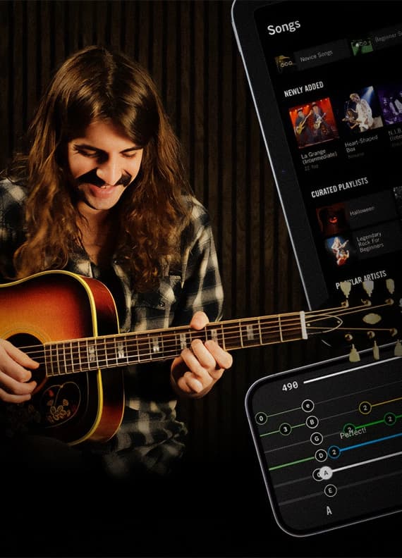 Person learning guitar with the best guitar app